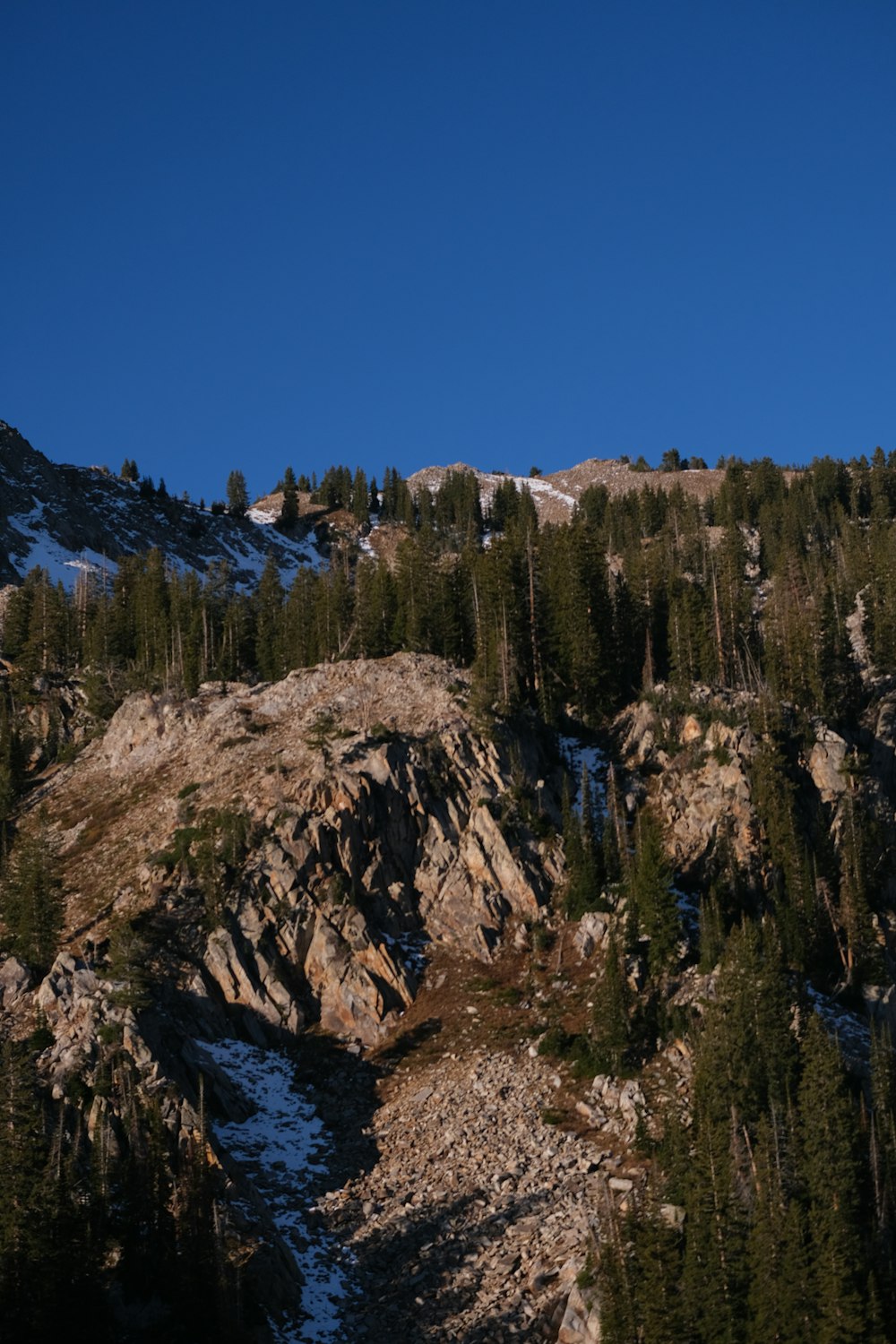 a snowboarder is going down a snowy mountain