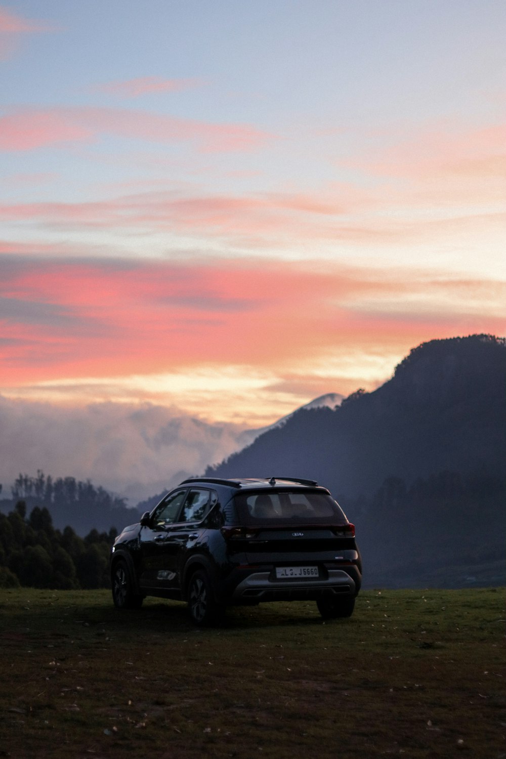 a car parked in a field with mountains in the background