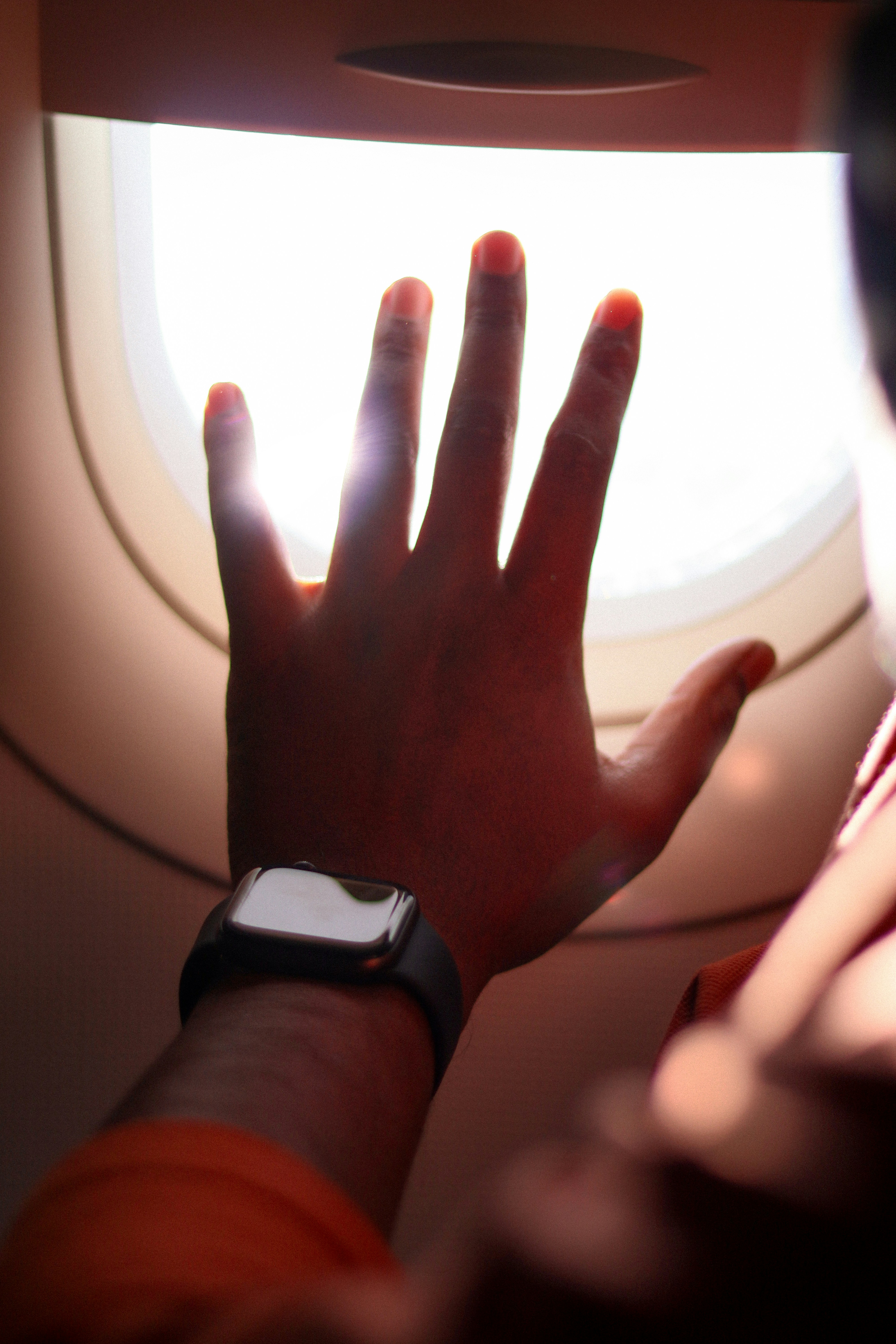 a person's hand on the arm of an airplane window