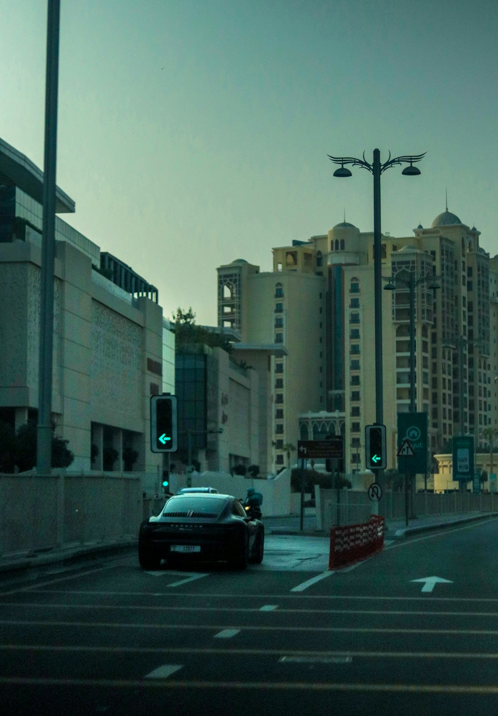 a car driving down a street next to tall buildings