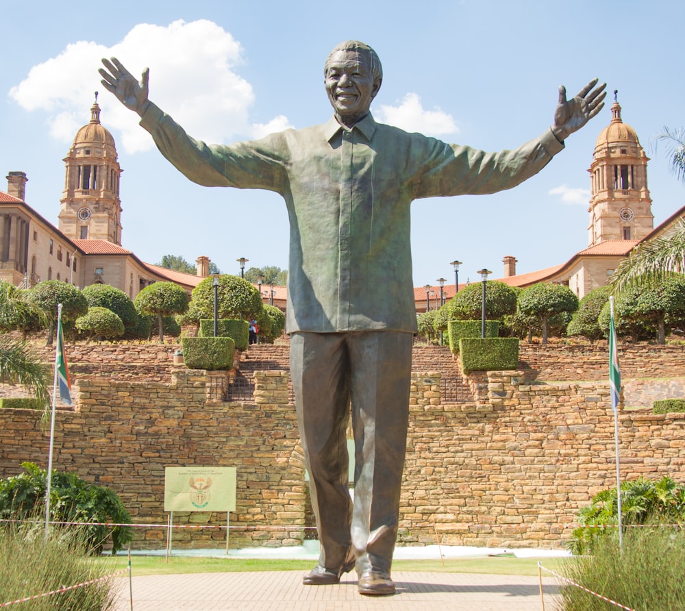 a statue of a man standing in front of a building