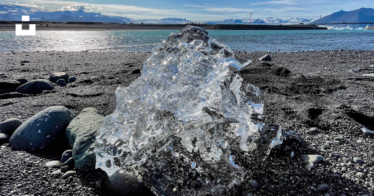Foto Un gran trozo de hielo sentado en la parte superior de una playa