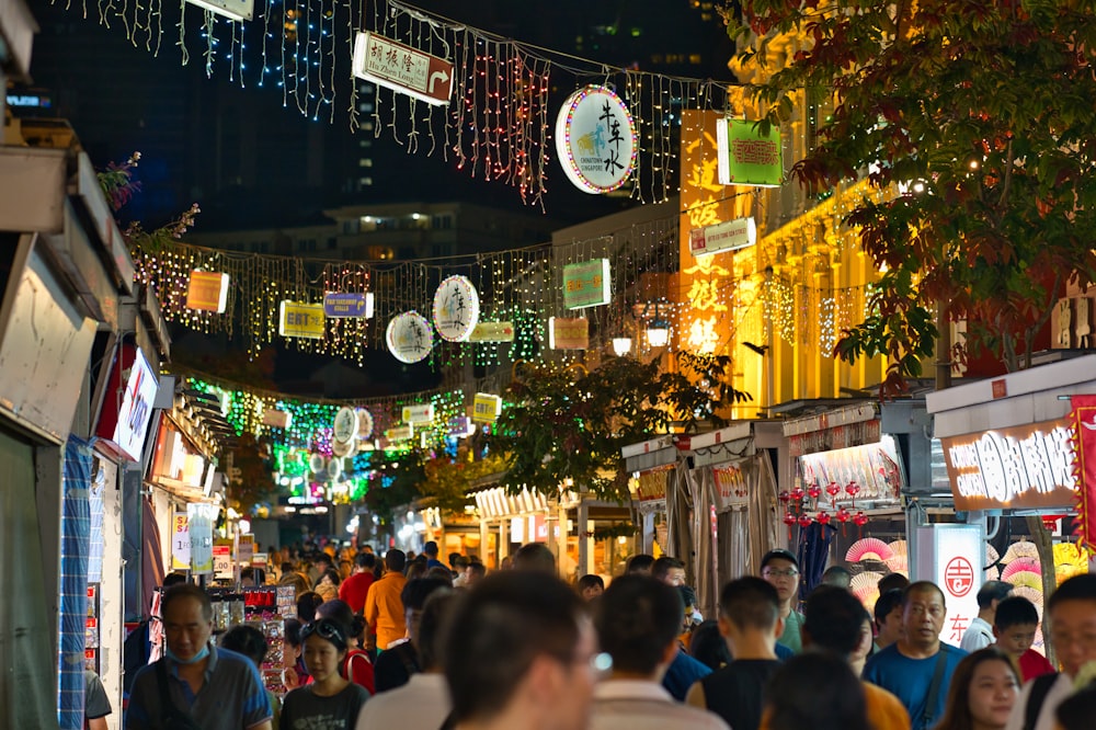 a crowd of people walking down a street at night