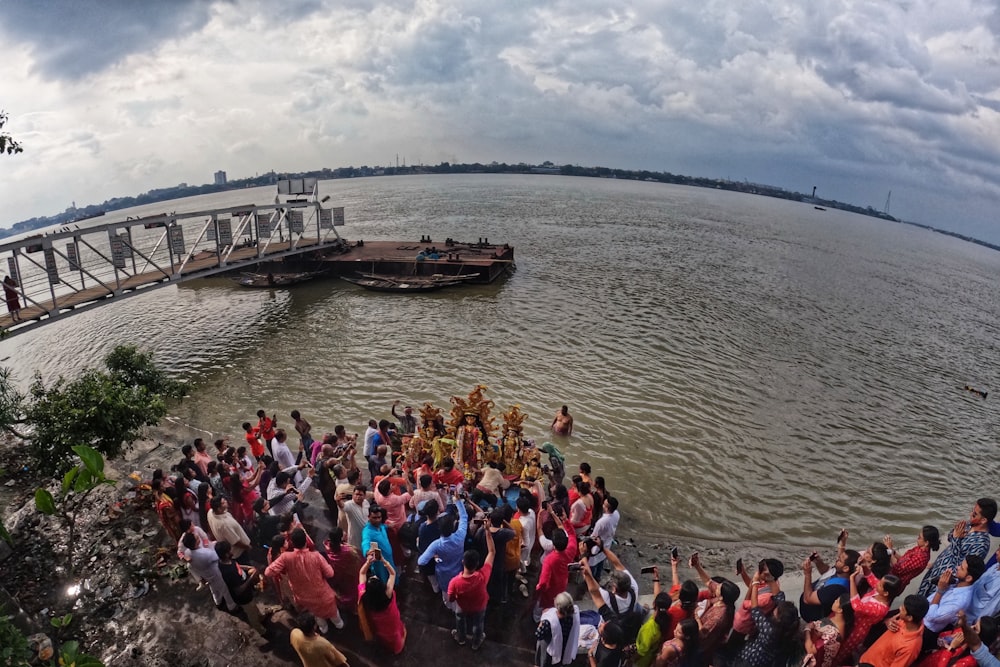 a group of people standing in front of a body of water