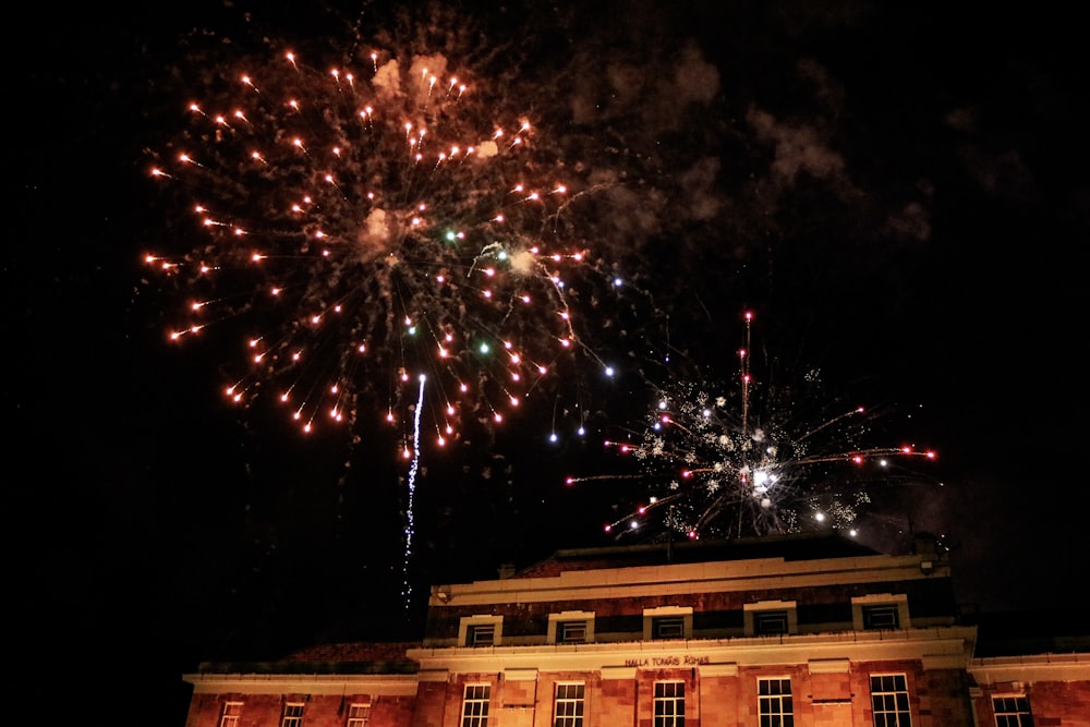 a large fireworks is lit up the sky above a building