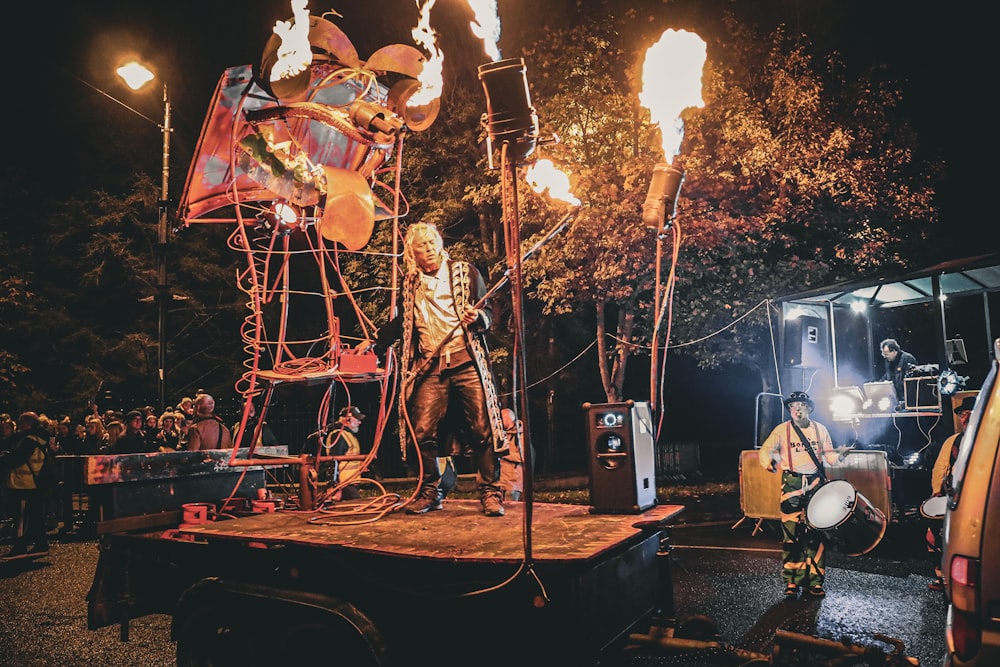 a man standing on top of a stage surrounded by fire