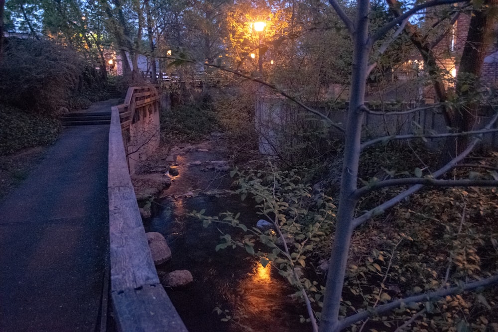 a wooden bridge over a small stream at night