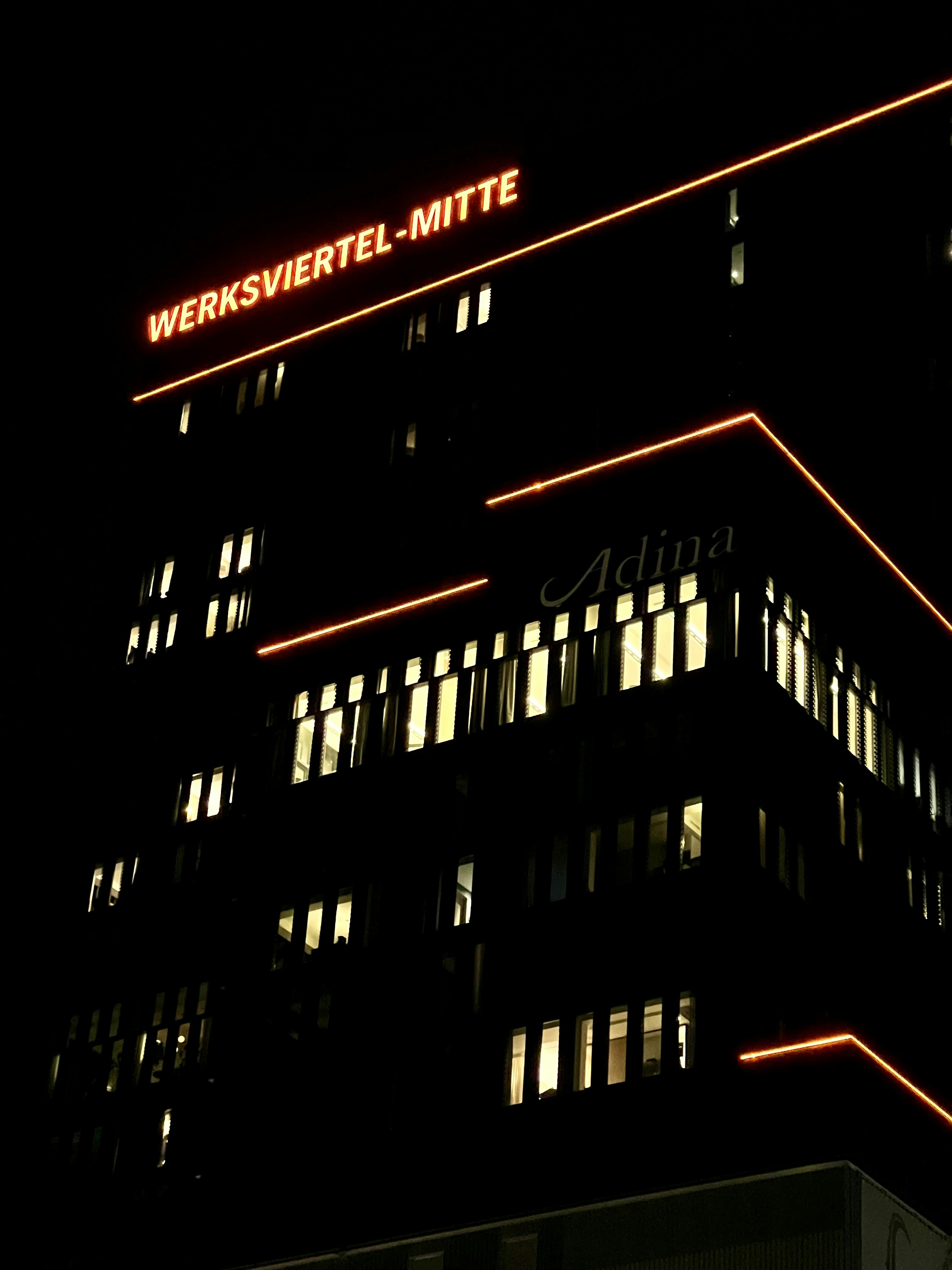 a very tall building with a neon sign on top of it