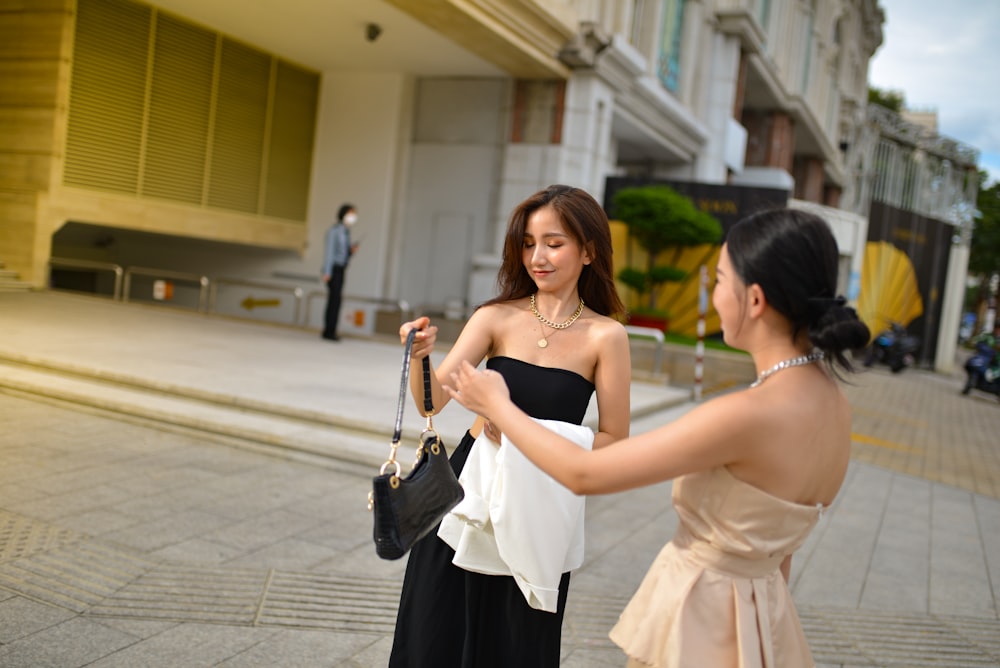 a woman in a black and white dress looking at a woman in a black and