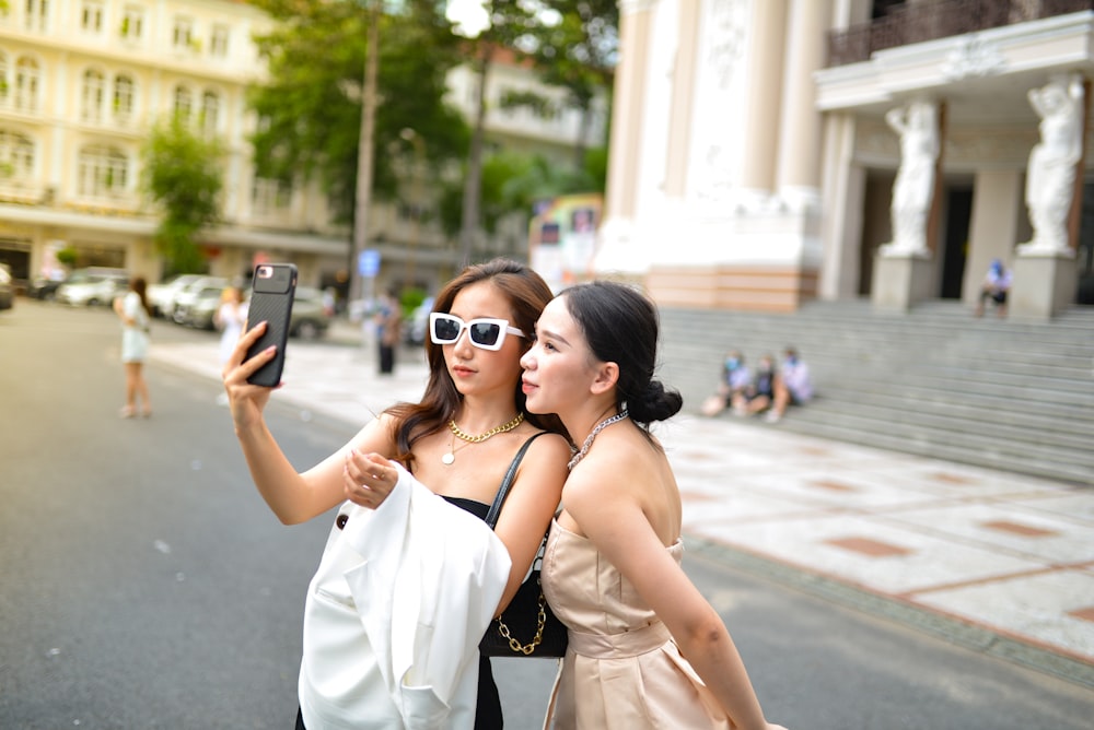 two women taking a picture with a cell phone