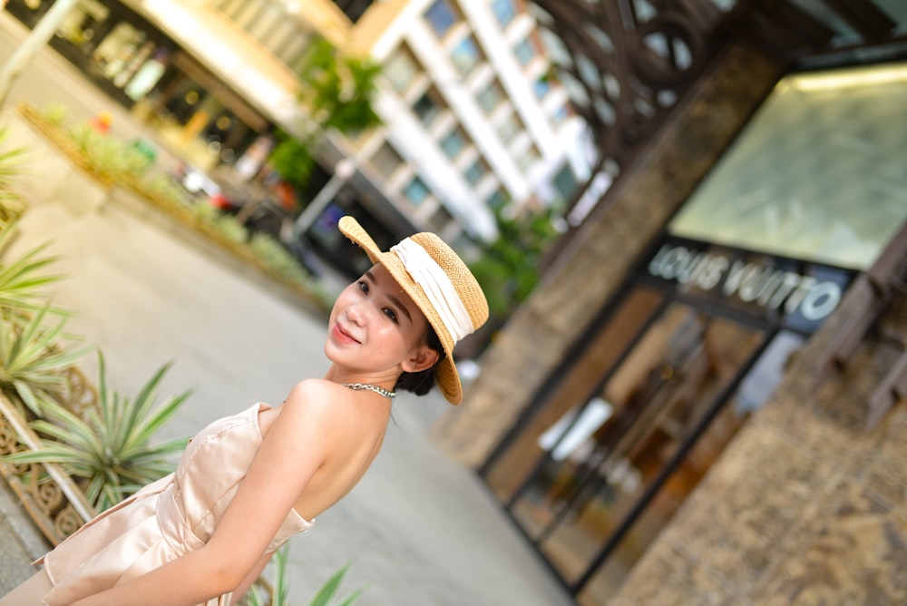 a woman in a dress and hat posing for a picture