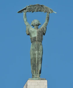 a statue of a woman holding a bird on top of her head