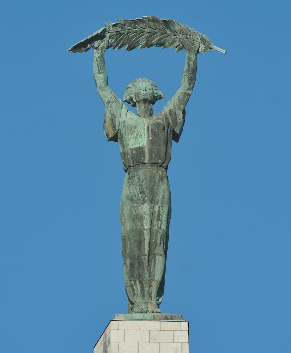 a statue of a woman holding a bird on top of her head