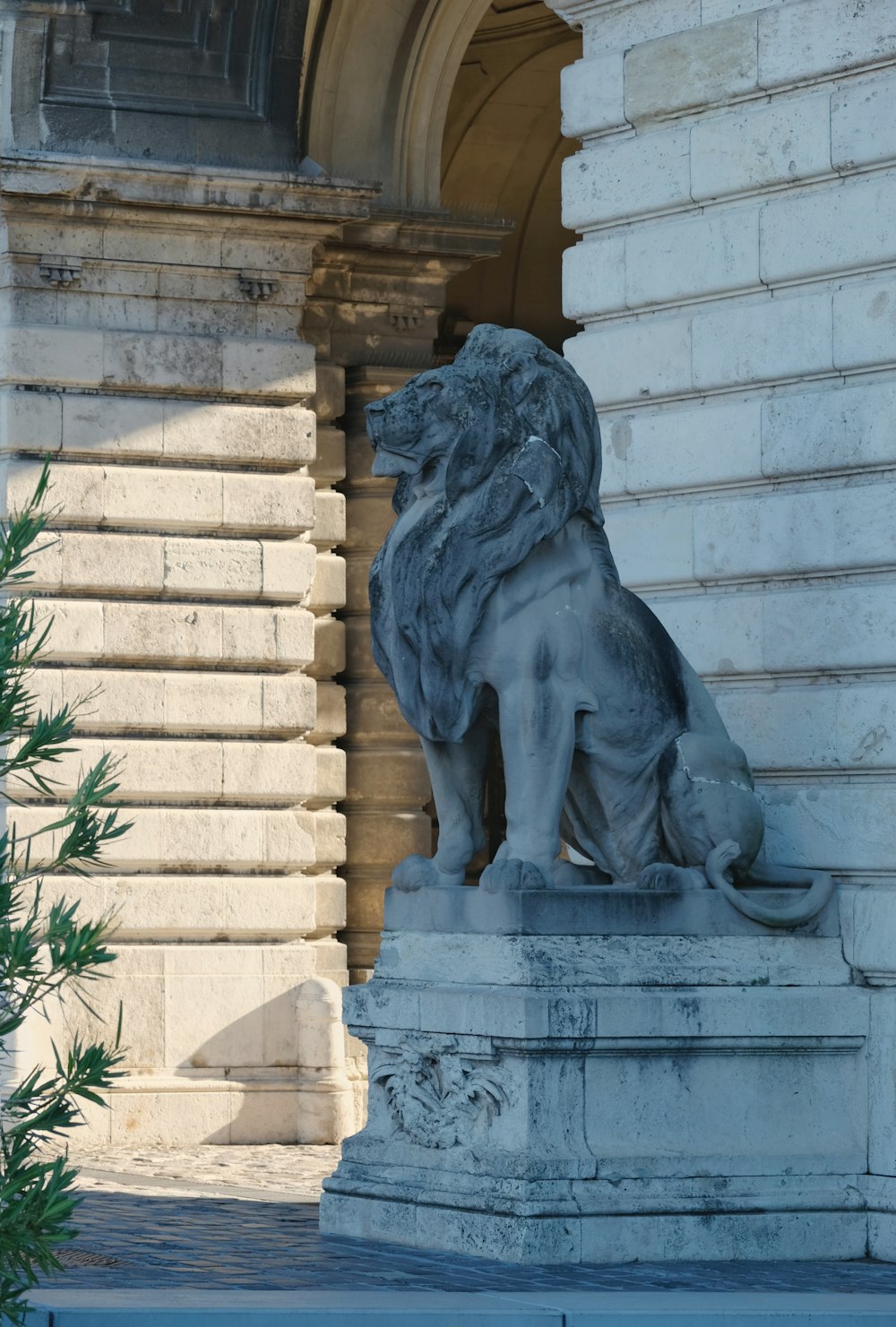 eine Statue eines Löwen, der vor einem Gebäude sitzt