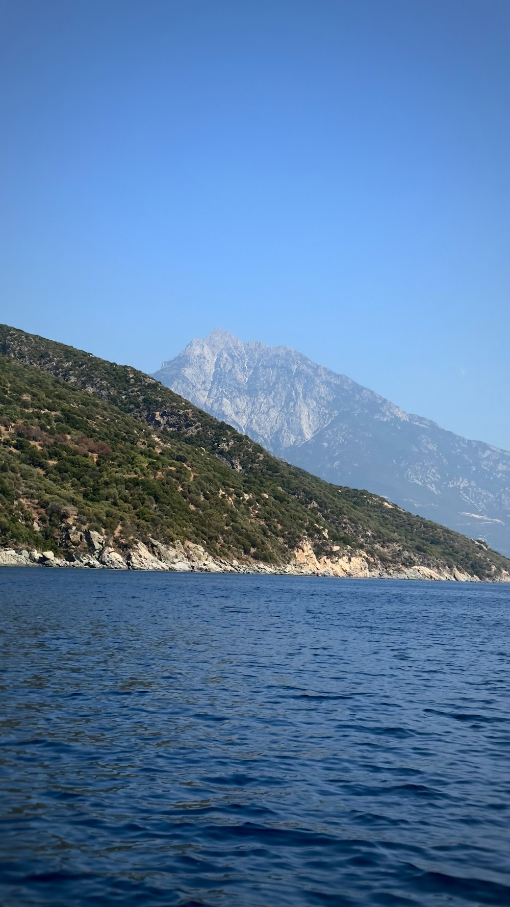 a large body of water with a mountain in the background