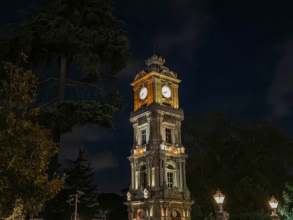 una grande torre dell'orologio illuminata di notte
