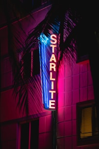 a neon sign is lit up on the side of a building