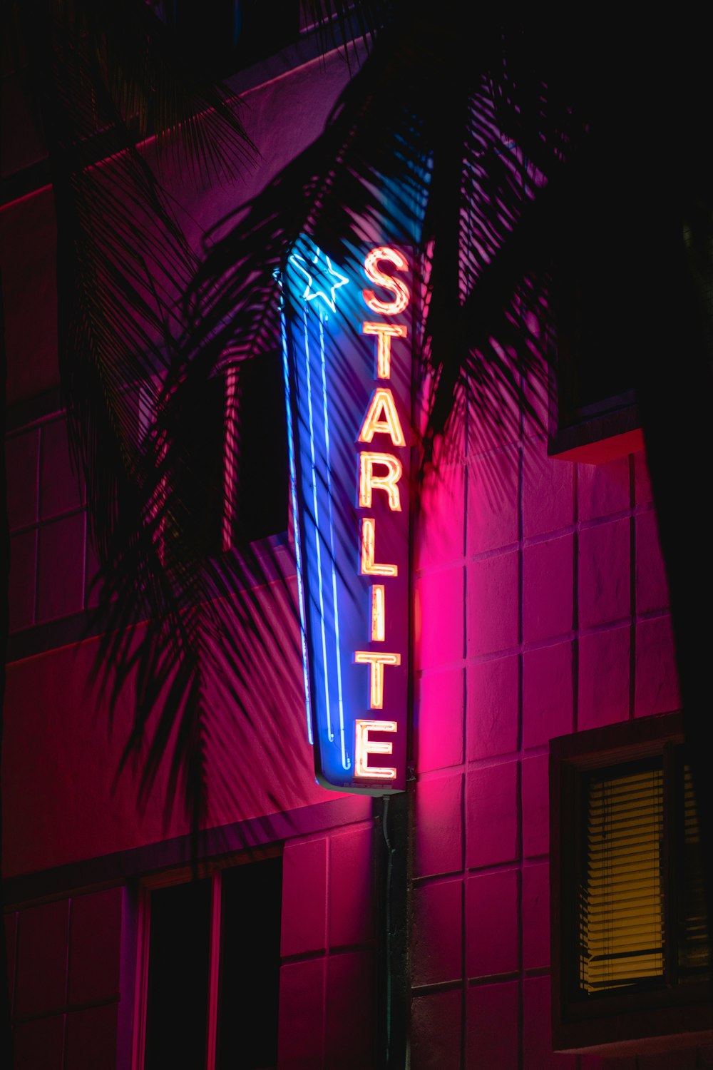 a neon sign is lit up on the side of a building