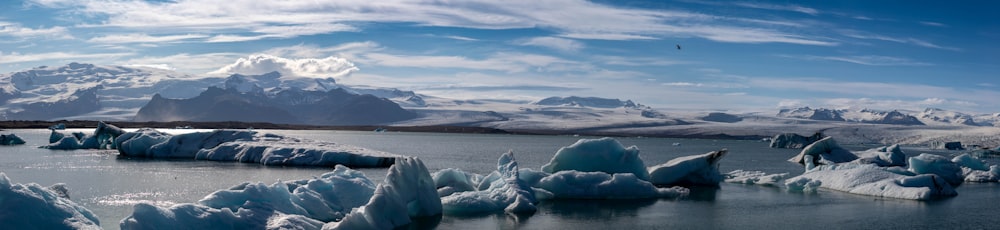 a group of icebergs floating on top of a lake