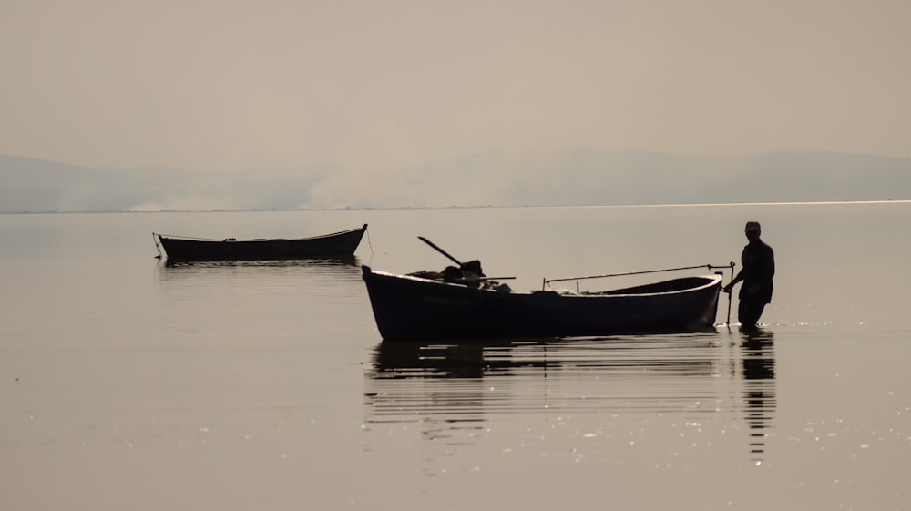 a man standing next to a boat in the water