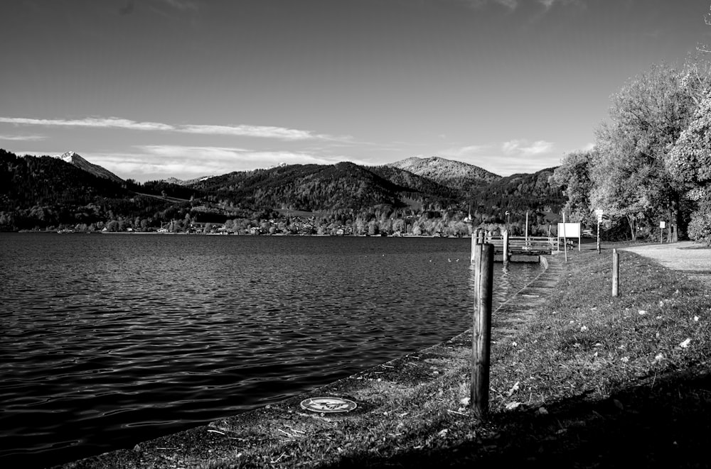 a black and white photo of a lake with mountains in the background