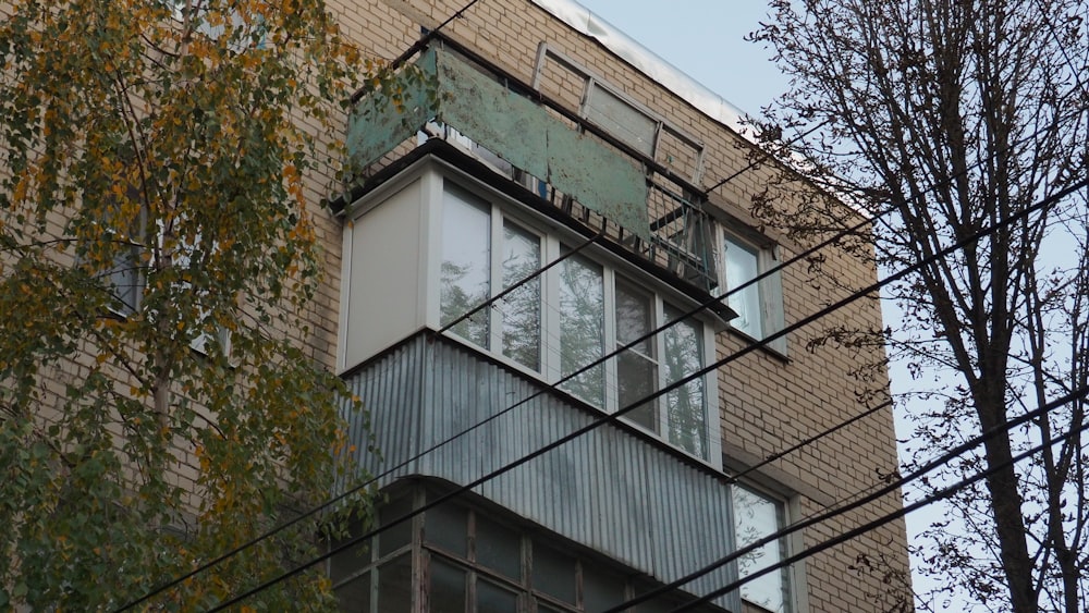 a tall building with lots of windows next to a tree