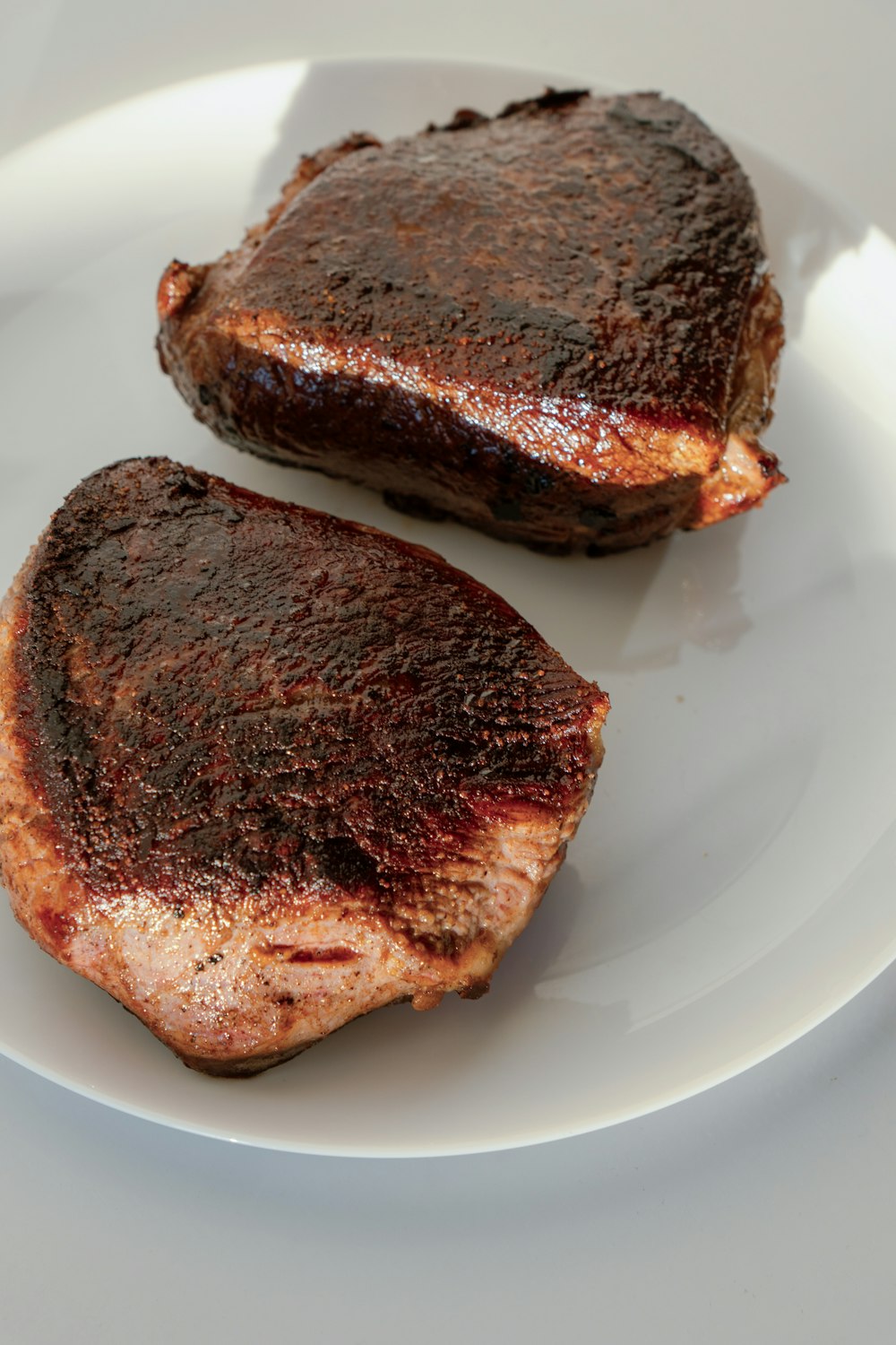 two pieces of meat on a white plate