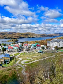 a scenic view of a town with a lake in the background