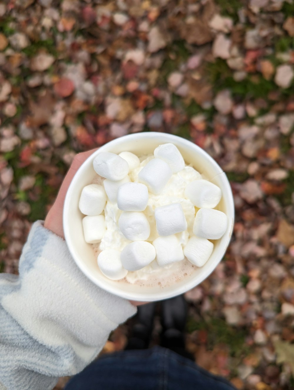 a person holding a cup filled with marshmallows