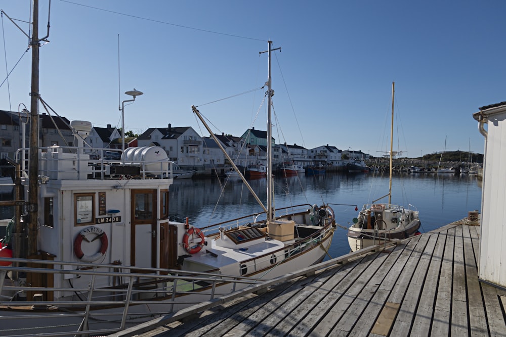 a boat docked at a pier with houses in the background