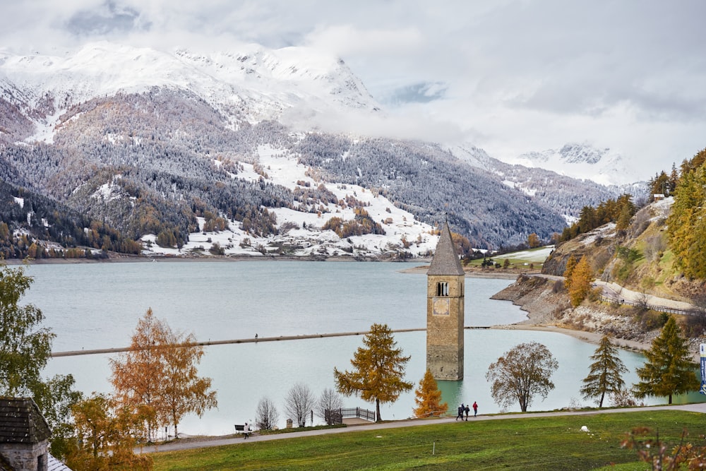 a large clock tower sitting on the side of a lake