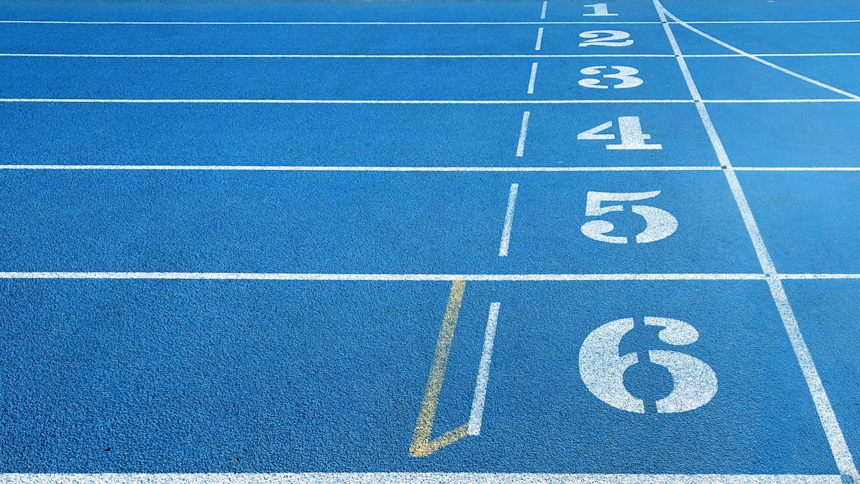 a blue running track with white numbers on it