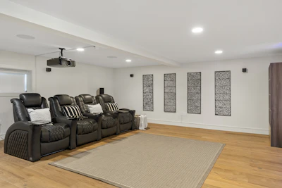 A stylish home theater system with surround sound speakers arranged around a couch.