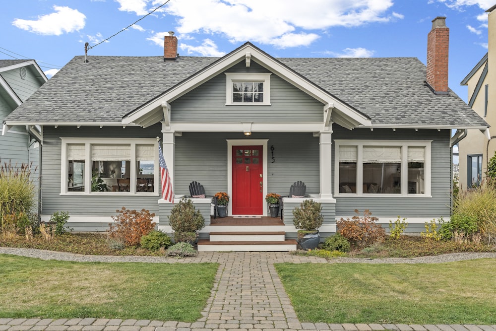 a gray house with a red door and a red front door