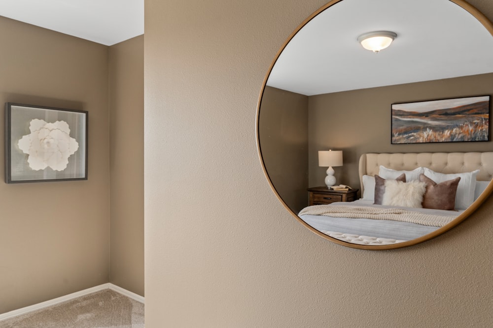 a bedroom with a large round mirror on the wall