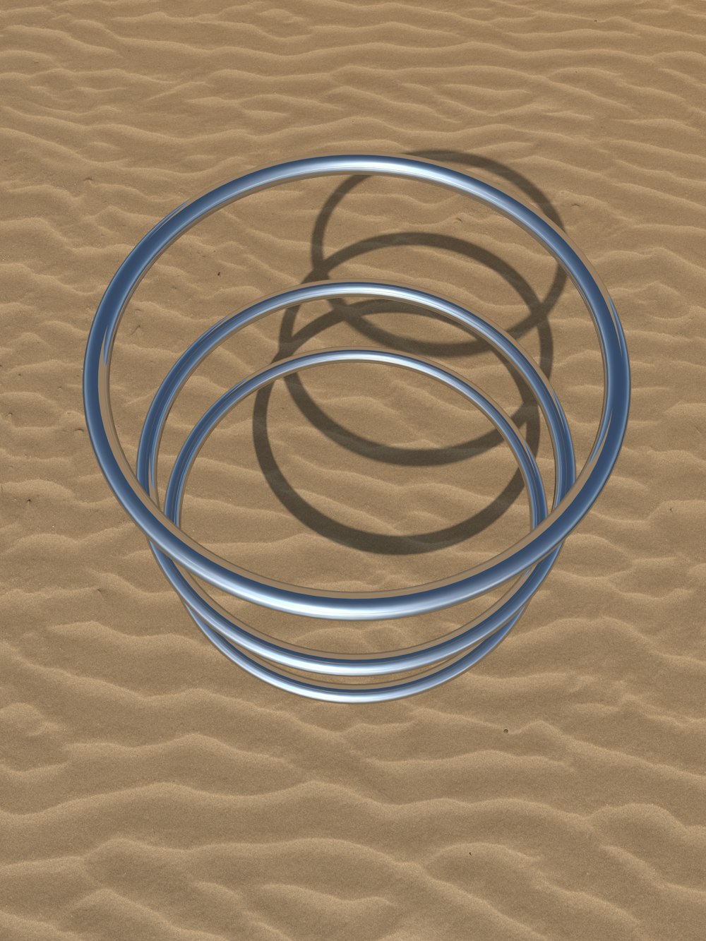 a group of metal rings sitting on top of a sandy beach
