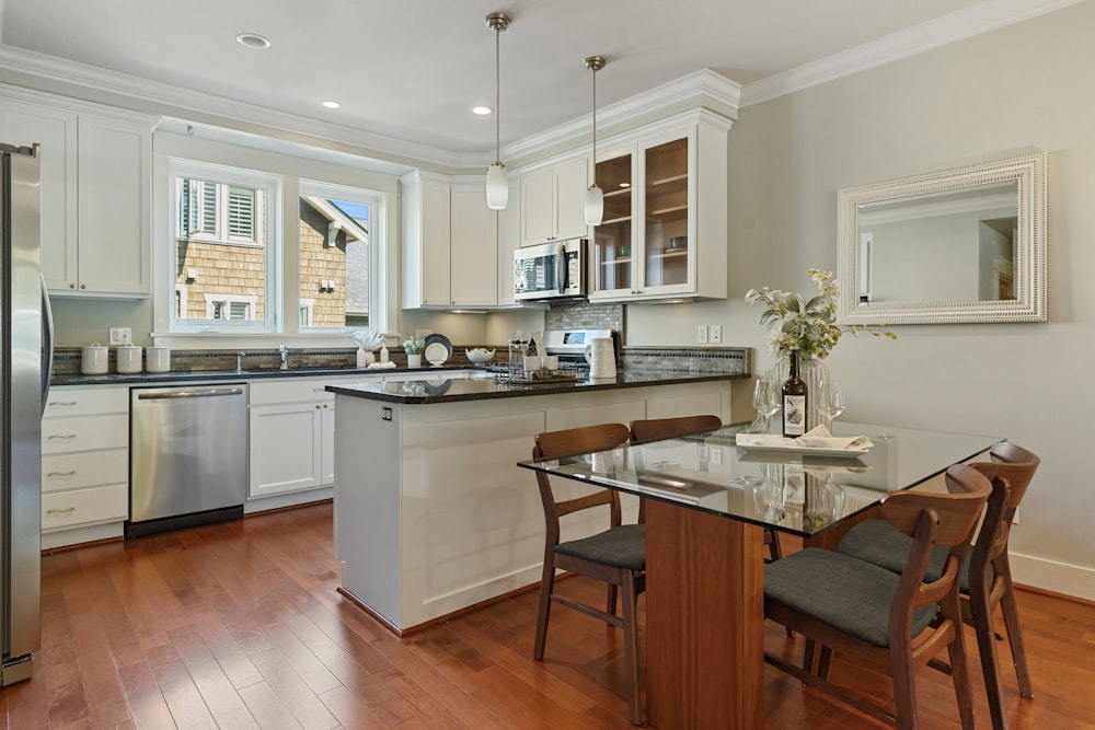 a kitchen with a glass table and a refrigerator