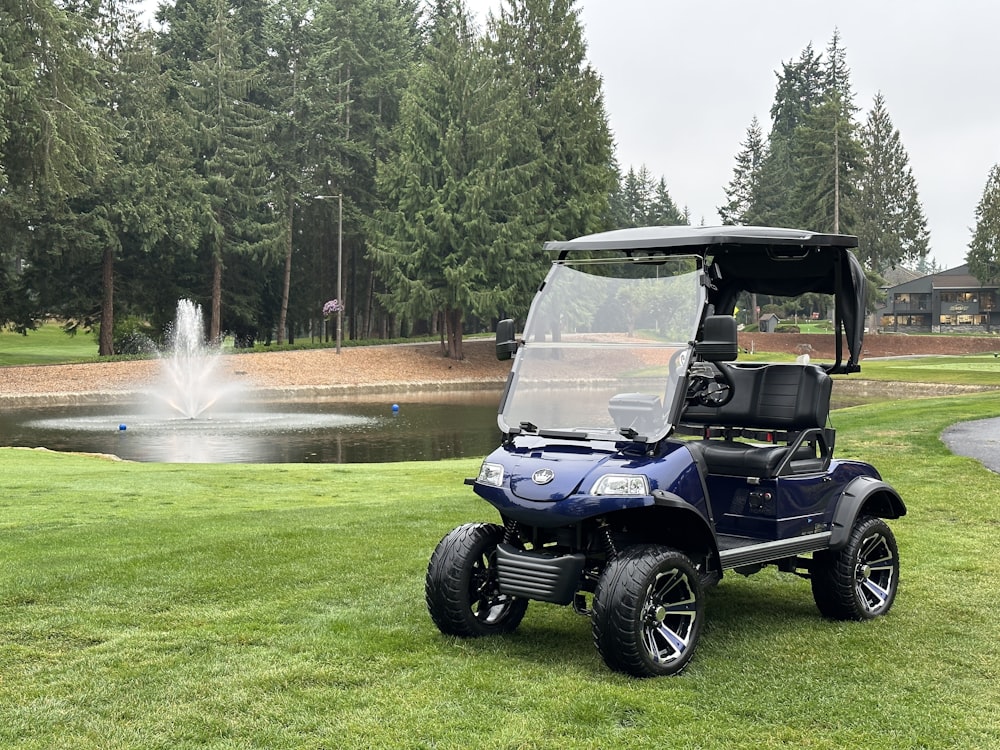 a golf cart parked in the grass near a pond