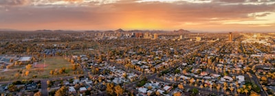 A sweeping aerial drone shot of downtown Denver at sunset, highlighting city lights.