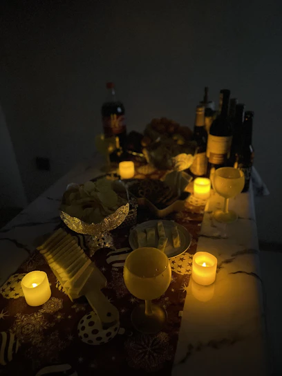 A warm, candlelit table set with an array of colorful Spanish pintxos and glasses of deep red wine.