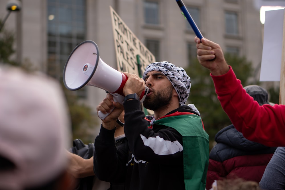 a man holding a megaphone in front of a crowd of people