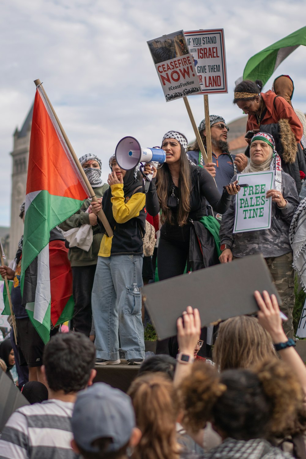 a crowd of people holding signs and flags