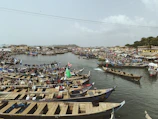 Bustling port of Conakry with colorful boats docked along the waterfront.