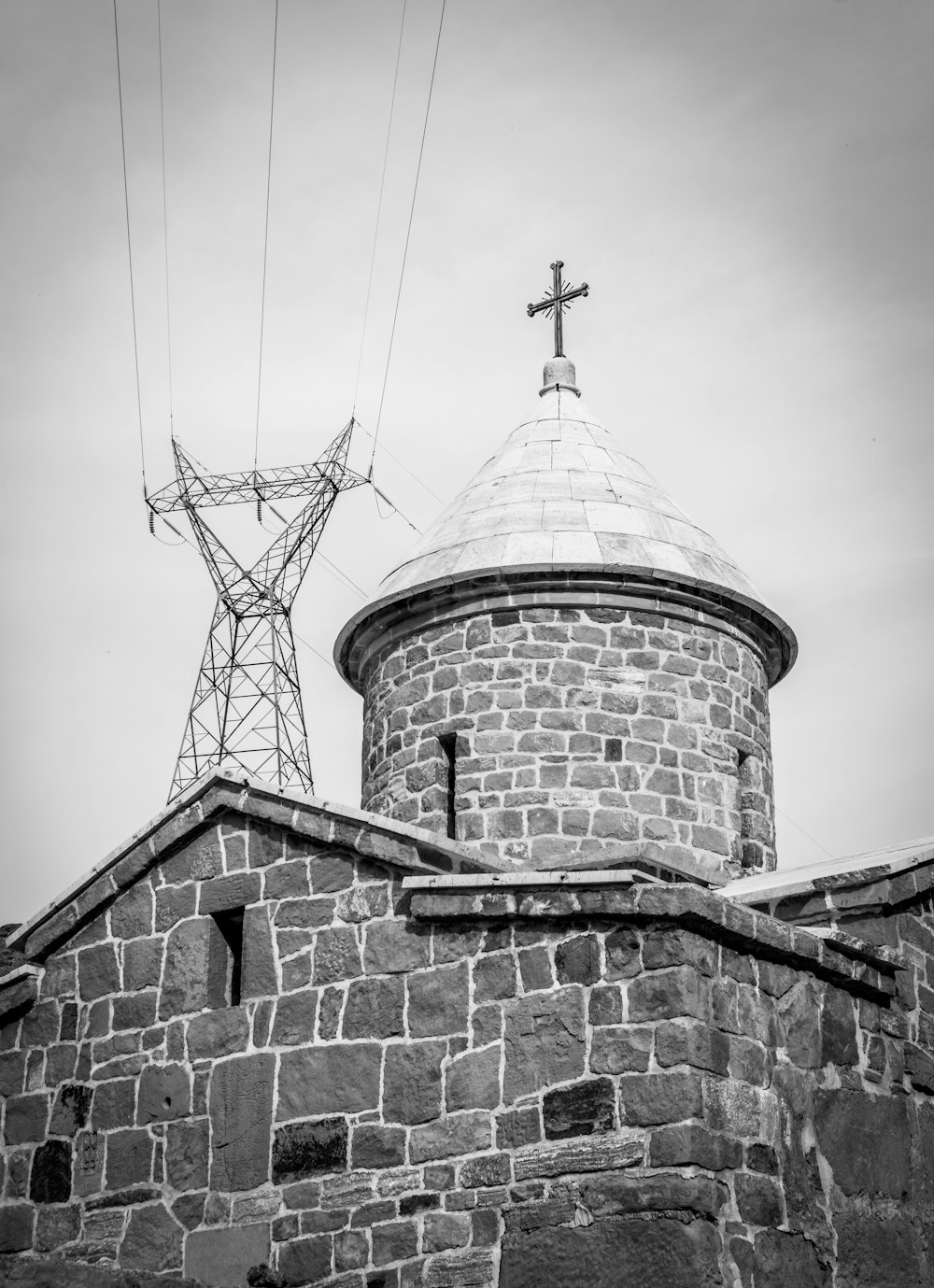 Una foto en blanco y negro de una torre con una cruz en la parte superior