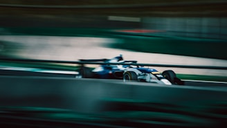 a racing car driving on a track in motion