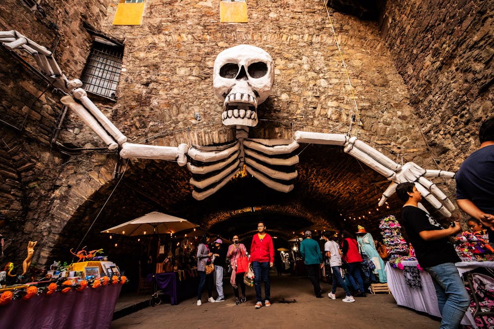 a group of people standing around a skeleton statue