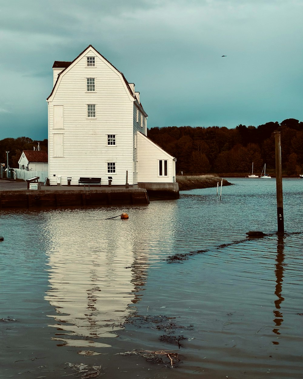 a white house sitting on top of a body of water