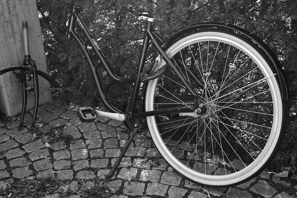 壁にもたれかかっている自転車の白黒写真