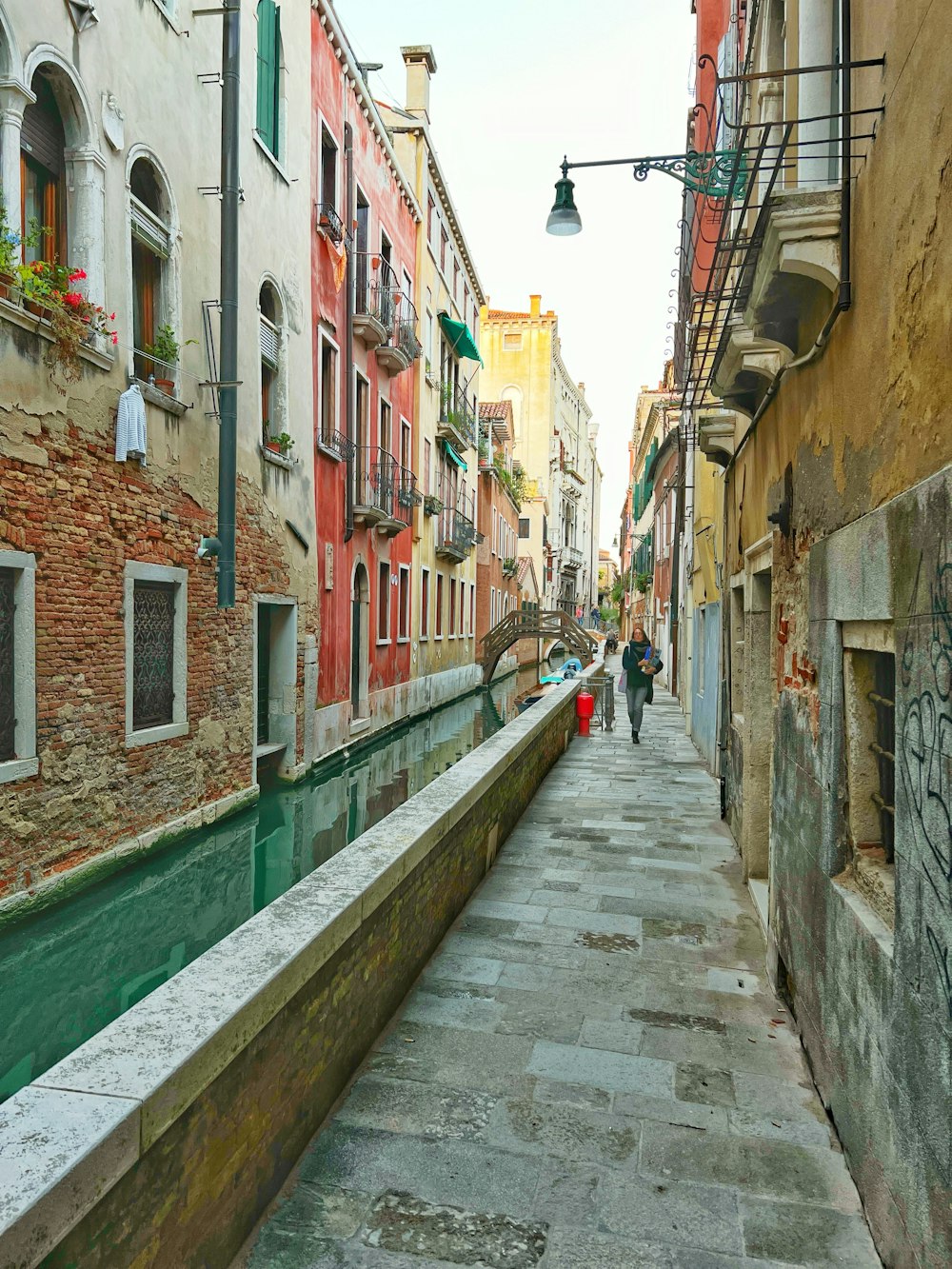 a narrow street lined with buildings next to a river