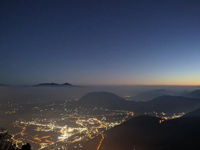 A panoramic view of a game world at dusk, blending dark tones with fiery highlights.